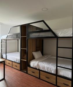 two bunk beds in a room with wooden floors at Hotel Laverdieri in Suba