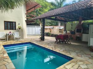 una piscina con patio e una casa di Pousada do Trevo a Parati Altre 12 foto