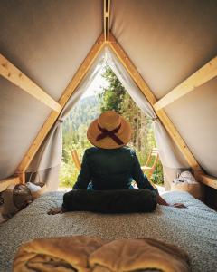 a person with a hat sitting in a tent at Campeggio Treinke Sauris in Sauris