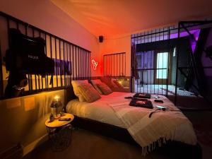 una camera da letto con un letto con una luce arancione di The Forbidden Suite - prison a Souppes-sur-Loing