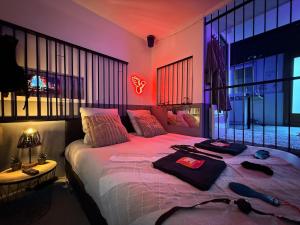 una camera da letto con un grande letto con illuminazione viola di The Forbidden Suite - prison a Souppes-sur-Loing
