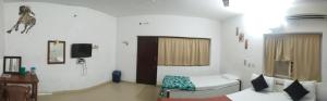 a hospital room with a bed and a tv at Rajkumar GuestHouse in Mahabalipuram +27 photos