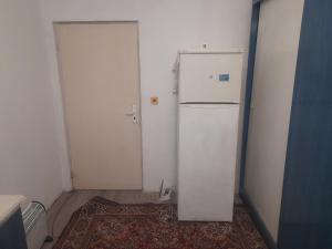 una nevera blanca en una habitación con puerta en prensess, en Varna