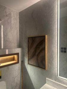 ein Bad mit einem Bild an der Wand in der Unterkunft Rose Garden Hotel فندق روز جاردن in Riad