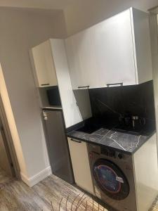 eine kleine Küche mit einem Herd und einer Waschmaschine in der Unterkunft Rose Garden Hotel فندق روز جاردن in Riad