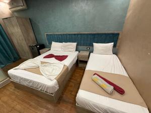 Dos camas en una habitación pequeña con toallas. en The-Cairo Plazario Downtown Hotel, en El Cairo