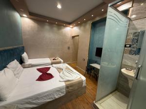 Habitación pequeña con 2 camas y ducha en The-Cairo Plazario Downtown Hotel, en El Cairo