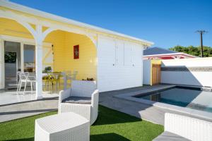 a backyard with a pool and chairs and a house at Villa Guenaslo 1 in Saint-François