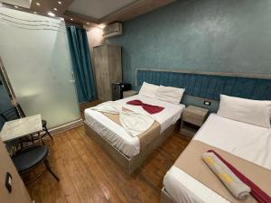 Una habitación de hotel con dos camas y una silla. en The-Cairo Plazario Downtown Hotel, en El Cairo