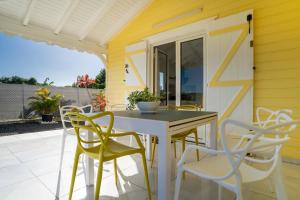 a yellow house with a table and chairs on a patio at Villa Guenaslo 1 in Saint-François