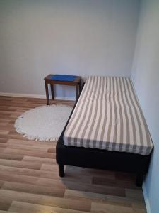 Traditional Finnish Lapland house at wild forest backyard! في كيمي: سرير في غرفة مع أرضية خشبية