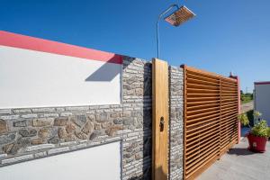 a brick wall with a gate and a street light at Villa Guenaslo 2 in Saint-François
