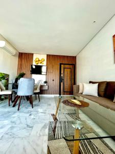 a living room with a couch and a table at Chic Cocoon & Impeccable Sea View in Zenata in Aïn Harrouda
