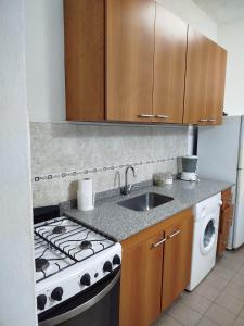 una cocina con estufa y fregadero en Estilo y confort en San Nicolás, en San Nicolás de los Arroyos 14 fotos más