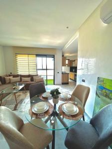 a living room with a glass table and chairs at Chic Cocoon & Impeccable Sea View in Zenata in Aïn Harrouda