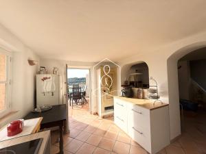 La Villa Andéria, petit cocon provençal في كاليان: مطبخ مع ثلاجة بيضاء وطاولة