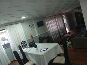 a dining room with a white table and chairs at Med House in Guaíra