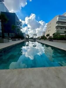 a swimming pool with a reflection of clouds in the water at Chic Cocoon & Impeccable Sea View in Zenata in Aïn Harrouda