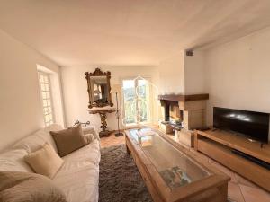 La Villa Andéria, petit cocon provençal في كاليان: غرفة معيشة مع أريكة وتلفزيون بشاشة مسطحة