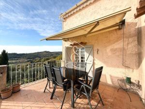 La Villa Andéria, petit cocon provençal في كاليان: فناء مع طاولة وكراسي على شرفة