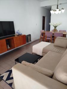 Una sala de estar con un sofá y un televisor de pantalla plana. en Estilo y confort en San Nicolás, en San Nicolás de los Arroyos