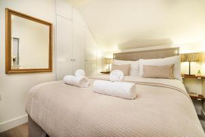 a bedroom with a large bed with towels on it at Enigma Lodge in Stratford-upon-Avon