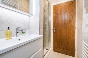 a bathroom with a sink and a wooden door at Enigma Lodge in Stratford-upon-Avon +25 photos
