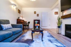 a living room with a couch and a table at Enigma Lodge in Stratford-upon-Avon