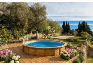 La Villa Andéria, petit cocon provençal في كاليان: حوض استحمام ساخن على سطح خشبي مع الزهور