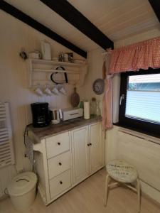 a small kitchen with a toilet and a window at Ferienhaus Bärenloch in Hilders