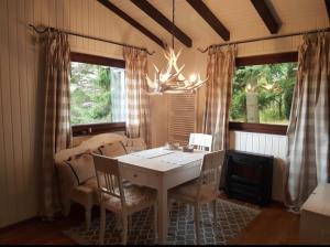 une salle à manger avec une table et des chaises et deux fenêtres dans l'établissement Ferienhaus Bärenloch, à Hilders