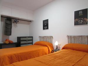 two beds in a room with orange sheets at MOJACAR HOME AND BEACH in Mojácar