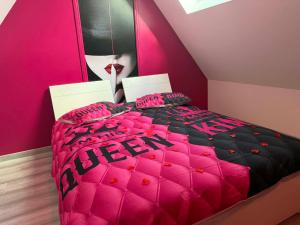 Love And Spa في Thun-Saint-Martin: سرير وردي واسود في الغرفة