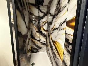 Love And Spa في Thun-Saint-Martin: حمام بجدار رخامي باللونين الأصفر والأسود