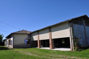 Ferme Les Pigeonnières في Canals: مبنى قديم به مرآب كبير