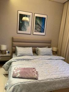 a bedroom with a large bed with a pink bag on it at Apartment suite in Manama