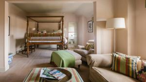 The White Swan Inn في بيكرينغ: غرفة معيشة مع أريكة وبيانو