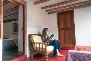 una mujer sentada en una silla leyendo un libro en Ninakancha - centro de retiro y sanación, en Coya