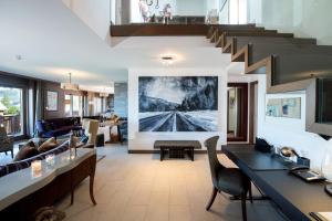 an open living room with a staircase and a living room at Chalet RoyAlp Hôtel & Spa in Villars-sur-Ollon