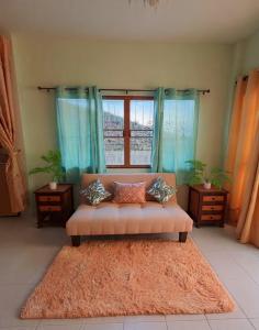 een woonkamer met een bank voor een raam bij Entire Home with King Bed in Chiang Mai