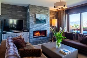 a living room with a couch and a fireplace at Chalet RoyAlp Hôtel & Spa in Villars-sur-Ollon