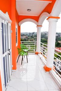 un balcone arancione e bianco con tavolo e sedie di Appartement Genève a Yaoundé Altre 3 foto