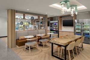 a restaurant with tables and chairs and a tv at TownePlace Suites by Marriott Miramar Beach Destin in Destin
