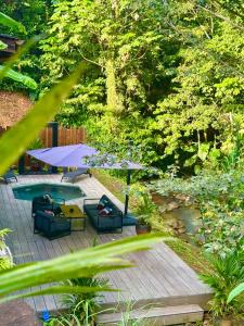 Chaya Lodge في بيتي-بور: فناء مع طاولة وكراسي ومظلة أرجوانية