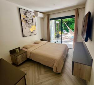 a bedroom with a bed and a door to a patio at Chaya Lodge in Petit-Bourg