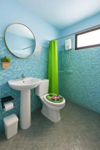 een badkamer met een toilet, een wastafel en een spiegel bij Entire Home with King Bed in Chiang Mai