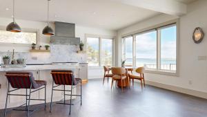 een keuken met een tafel, stoelen en ramen bij Tidal House in Surfside