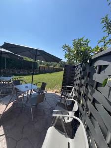 a patio with tables and chairs and an umbrella at Hotel Rural El Pingón in Manzanal de Arriba