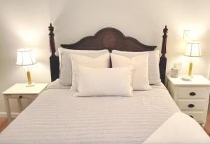 a white bed with white pillows and two night stands at The Great Escape, Black Mountain in Black Mountain