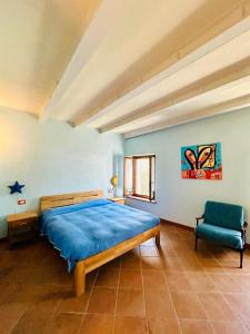 a bedroom with a blue bed and a chair at Agribirrificio Corte Petacchi in Volta Mantovana
